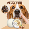 A dog's face and paw with a hand applying Paw & Nose Balm, next to the product jar.