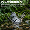 Gray silicone dog rain boots being washed in a stream over mossy rocks.