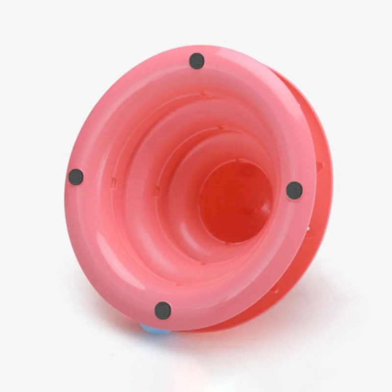 A pink 3-layer cat turntable toy with balls and a scratching board viewed from above.