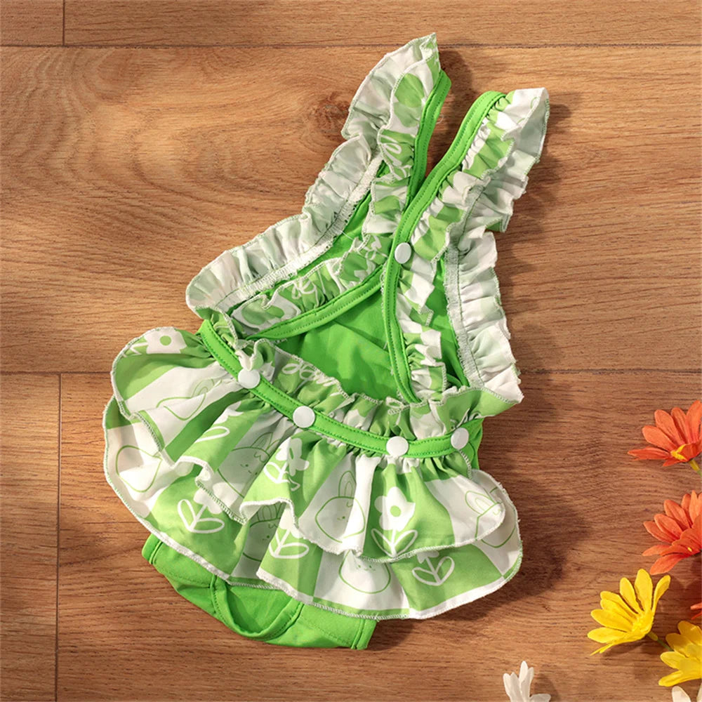 Green and white ruffled reusable dog diaper pants for small breeds displayed on a wooden surface.