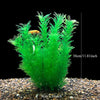 Plante aquatique artificielle vert vif aux feuilles plumeuses, exposée dans un gravier naturel.