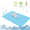 A light blue washable cooling dog mat is shown with a white dog lying on it, surrounded by ice.