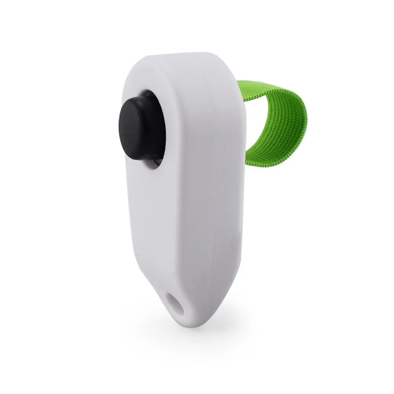 A white pet training clicker with a black button and a green textured grip.
