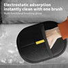 Black multi-functional brushing glove with an orange brush shown on a gray surface.