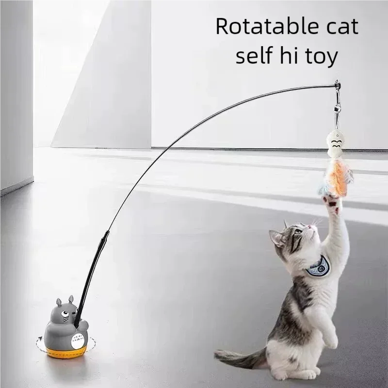 A cat is playing with a rotatable cat self hi toy wand that has a bell attached.