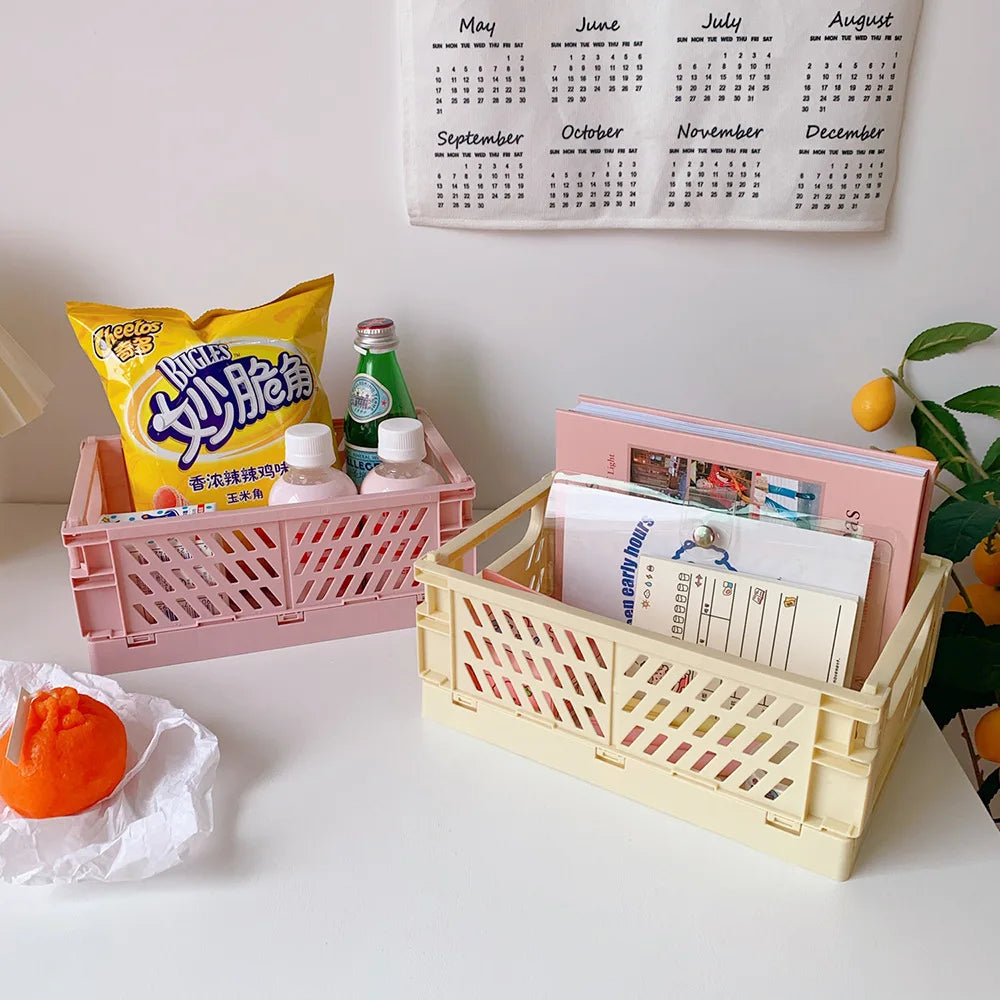 Pinker Plastik-Aufbewahrungskorb gefüllt mit Gegenständen wie einer gelben Tasche, einer grünen Flasche und Papier vor weißem