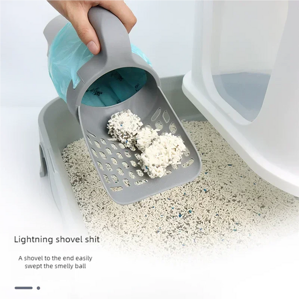 A hand is using a gray integrated cat litter scoop to pick up a ball of litter from a litter box.