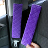 Purple plush car seat belt shoulder protector hanging on a car door panel.