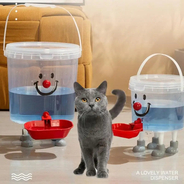 A gray cat stands next to a clear plastic water dispenser with a lid and a red bowl, demonstrating the pet water dispenser.