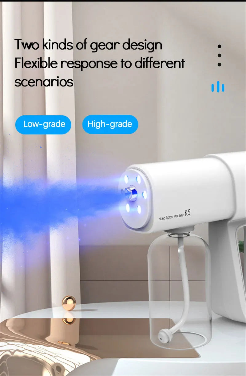 A white electric nano spray machine is shown spraying a blue mist in a modern indoor setting.