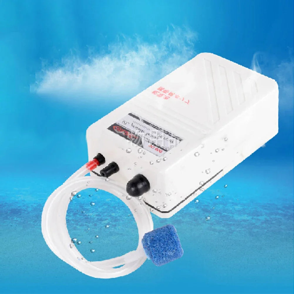Weiße, portable Aquarium-Luftpumpe mit klarem Schlauch und blauer Schwamm vor blauem Hintergrund.