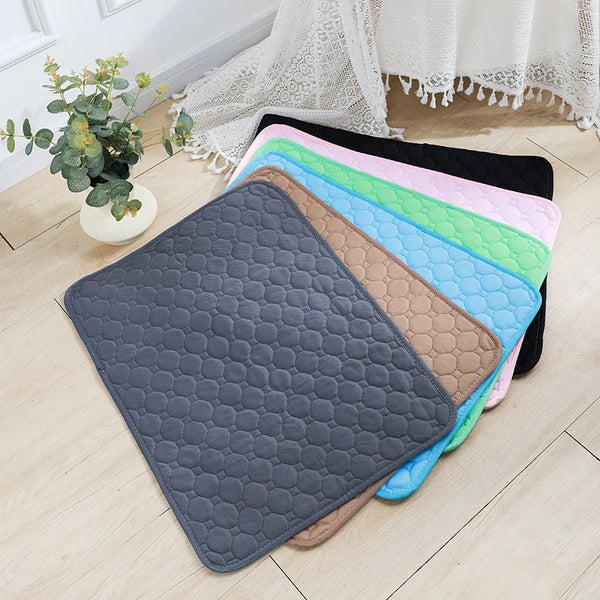 A stack of colorful, hexagonal reusable washable pet training mats on a light wooden floor.