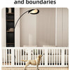 A light tan dog is standing in front of a white wooden pet fence cage with vertical slats.