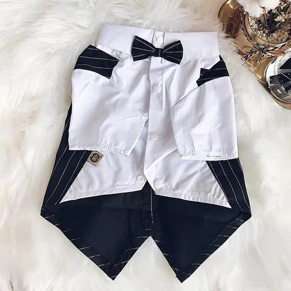 A white shirt with black accents and a black bow tie laid on a white fluffy surface.