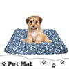 A fluffy light brown dog is lying on a blue patterned pet mat.
