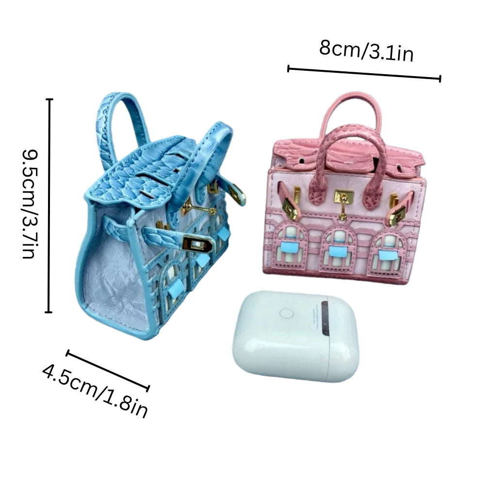 A pink and blue handcrafted mini house-shaped bag with a puppy keychain charm and a white electronic device.