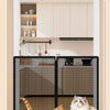 A foldable metal mesh pet gate and barrier is shown in a kitchen cabinet, with two cats standing in front of it.