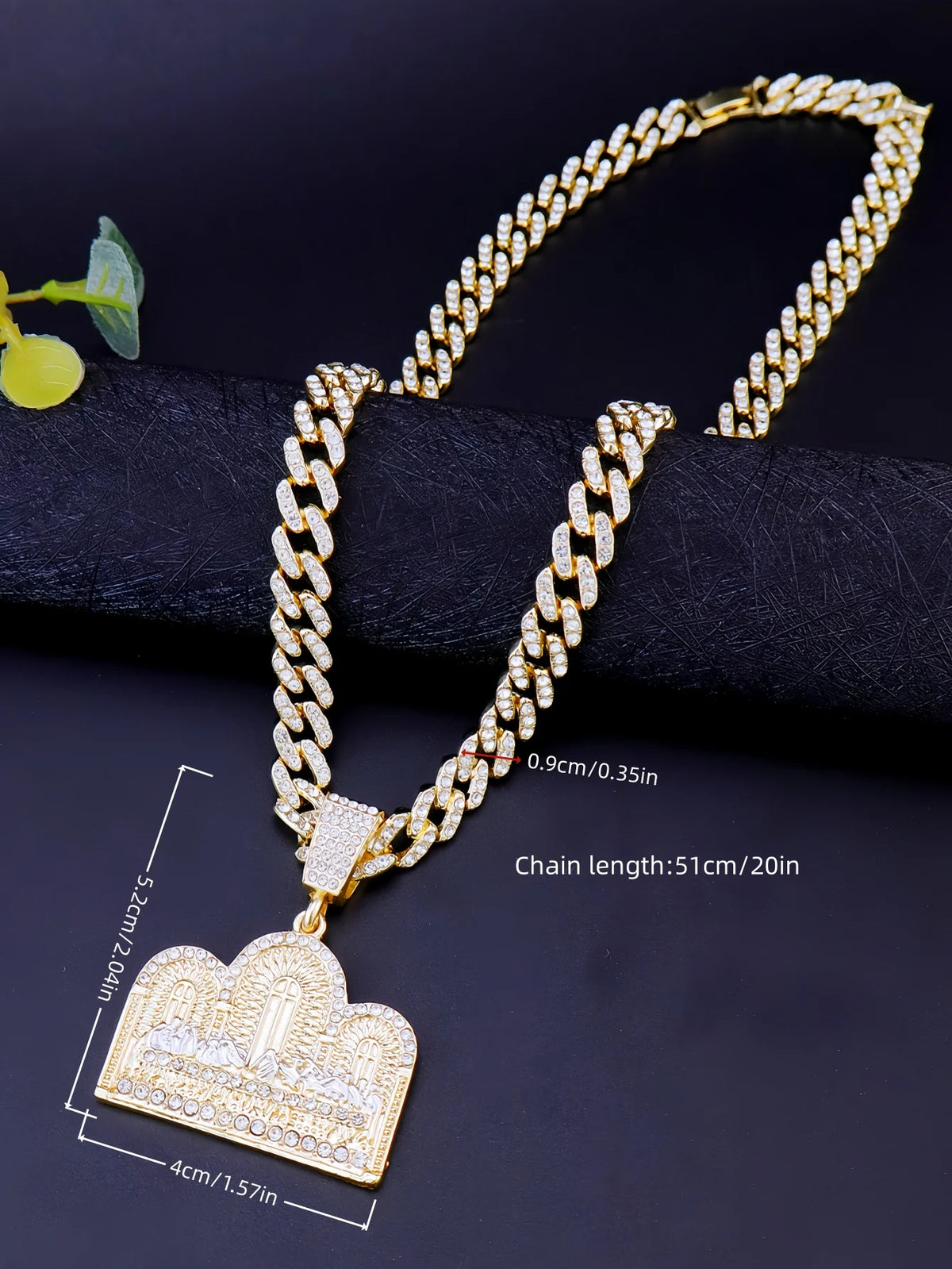 Collar de cadena chapado en oro con colgante medallón de la Última Cena sobre fondo negro.