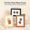 A wooden photo frame featuring a black paw print design, displayed on a textured surface.