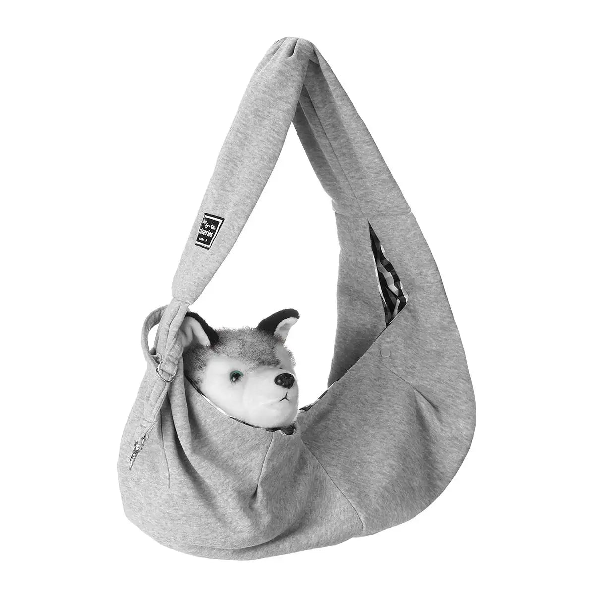 A gray pet carrier sling bag with a fabric strap and a small dog's head peeking out.