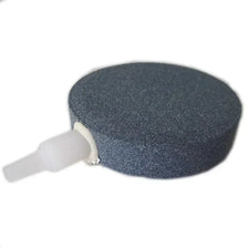 A round, dark gray air stone disc with a white connector for aquarium oxygenation.