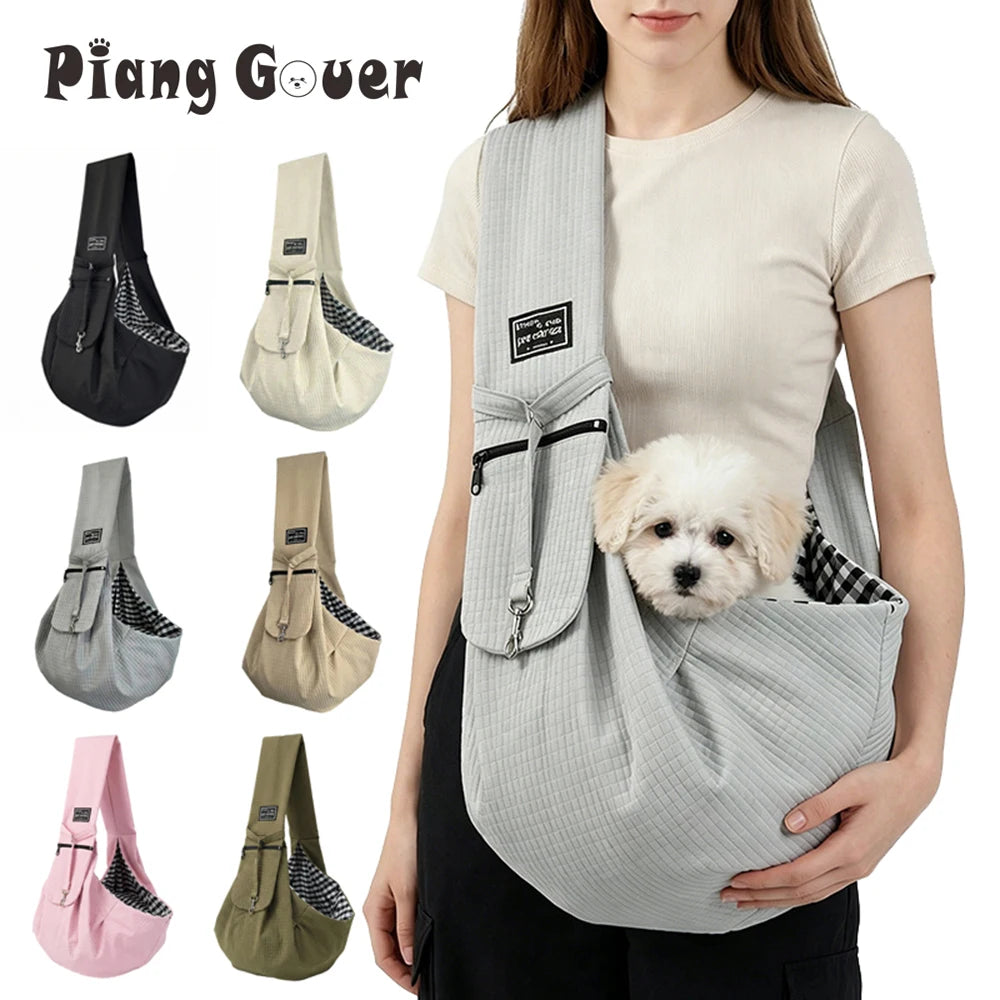 A woman is holding a grey crossbody pet carrier bag with a fluffy white dog inside.