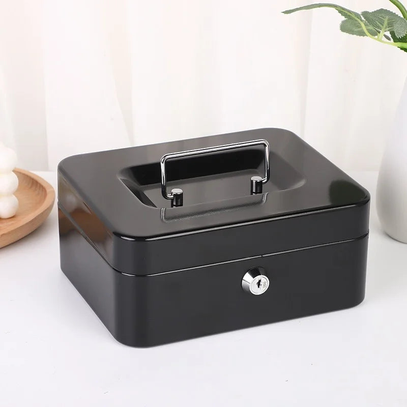 A black portable metal cash box with a silver lock and keys, shown from above.