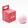 A pink cardboard box for an interactive cat sounding toy with catnip, next to the spherical toy.
