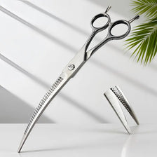 Silver curved pet hair trimming scissors with serrated blades resting on a white surface.