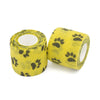 Un rollo de vendas adhesivas para tatuajes amarillas para mascotas con estampado de huella negra.
