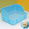Una caja de arena rejilla azul claro desmontable para mamíferos pequeños, mostrada sobre una superficie blanca.