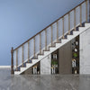 A modern interior featuring a staircase with glass railings and wooden steps against a light gray wall.