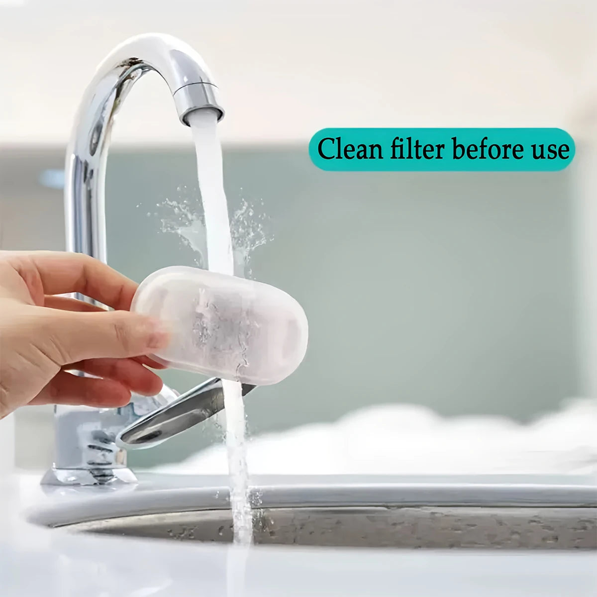 A hand is cleaning a replacement filter under a faucet for pet water fountain use.