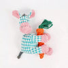 A handmade plush toy of a donkey with pink and teal patterned fabric and green grass tufts.