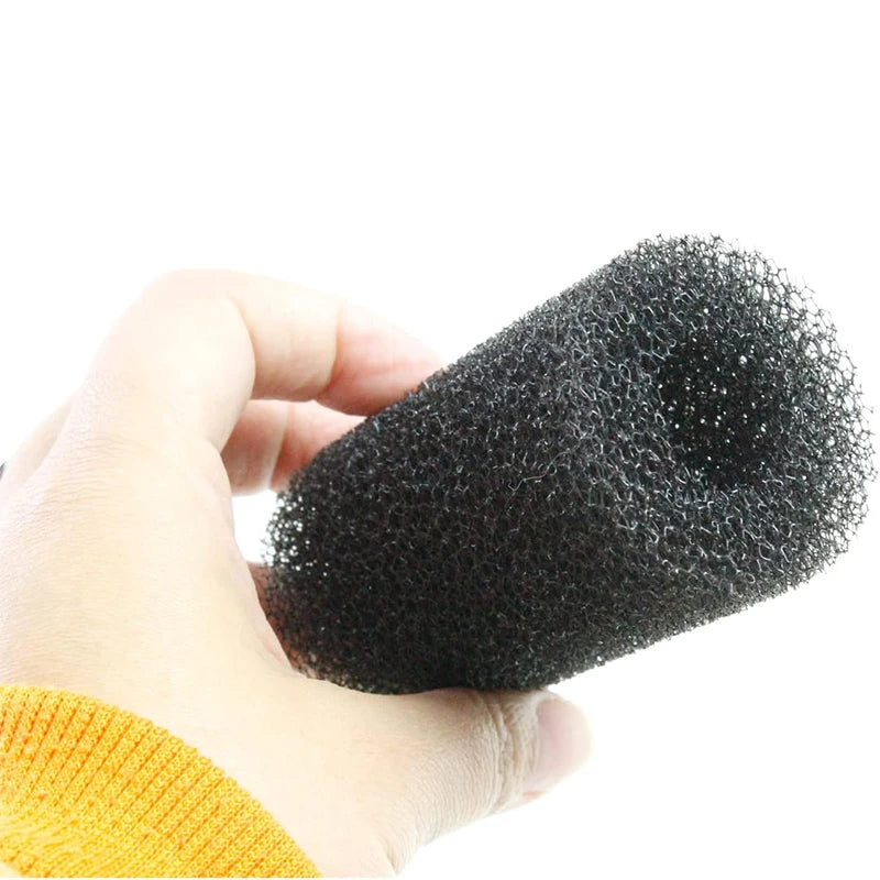 Une main tient une éponge pré-filtre noire pour aquarium et petits animaux.