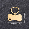 A gold-colored bone-shaped dog ID tag with a circular keyring, shown against a dark gray background.