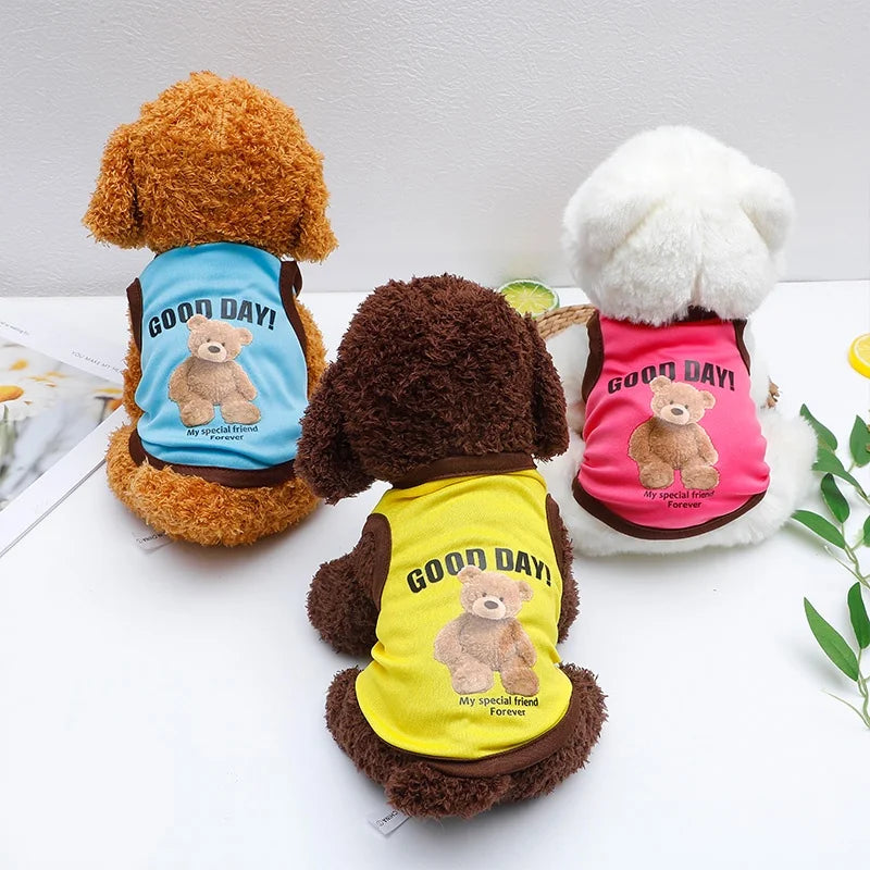 Three plush bear dog pets wearing colorful vests with embroidered bears