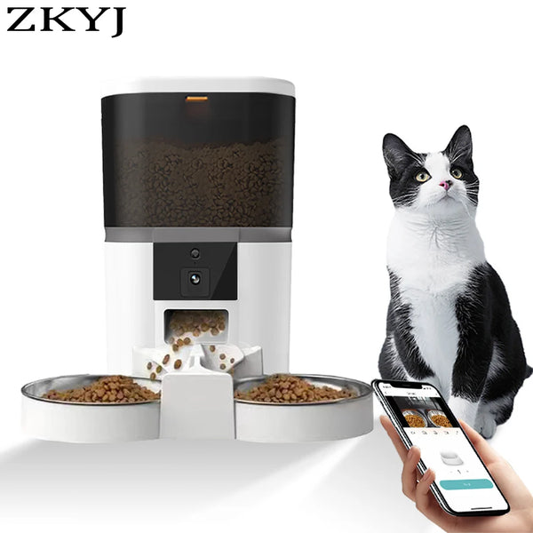 A white automatic pet feeder for cats and dogs is shown with a cat nearby and food bowls.
