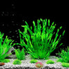 A dense clump of bright green artificial aquarium plants growing in light gravel.