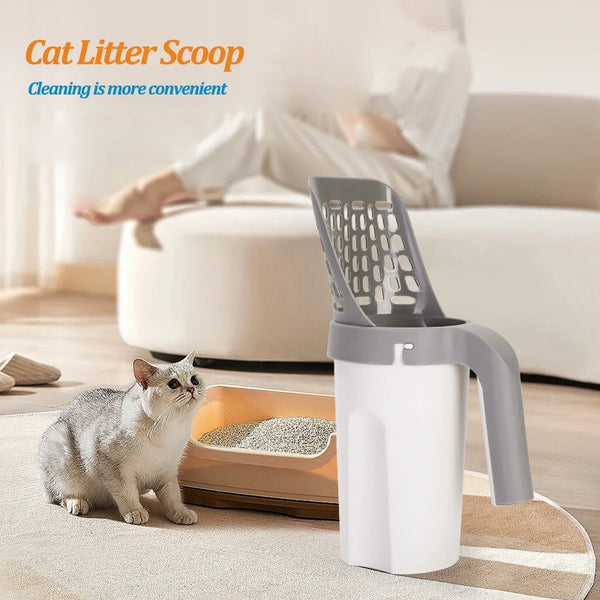 A gray cat sits next to a white reusable pet litter scoop with a gray handle and white body on a rug.
