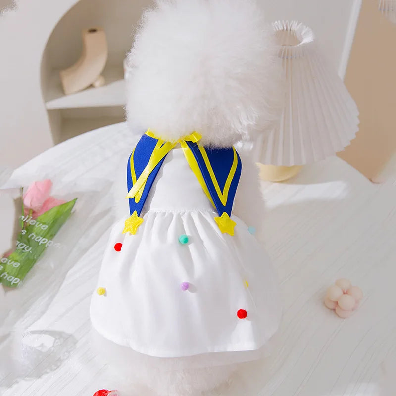 Vestido de malla blanca para perros con acentos azules y amarillos y un cuello blanco peludo.