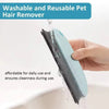 A hand is using a light blue reusable pet hair remover brush to clean surfaces.