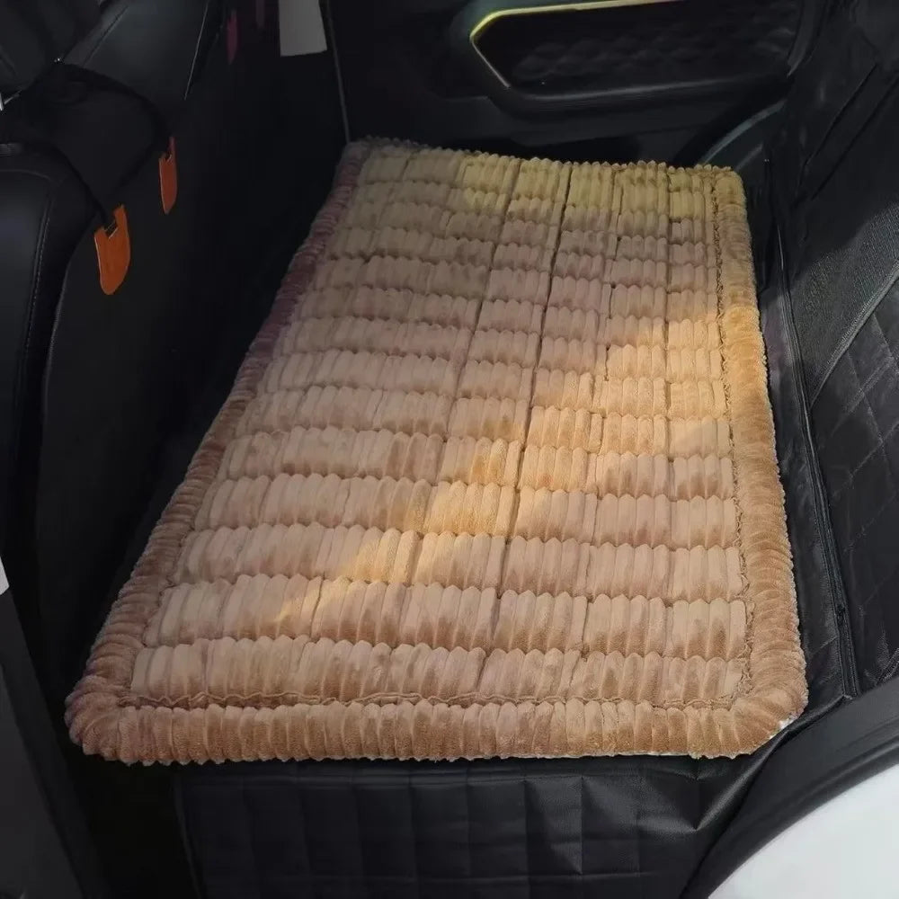 A beige plaid flannel pet seat protector and car mat placed in a black car interior.