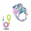 A purple and teal adjustable dog harness with reflective straps is shown next to a coiled leash.
