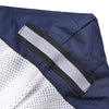 A close-up of a navy blue and white dog raincoat showing a gray reflective stripe detail.