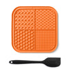 Orange silicone lick mat for dogs and cats with suction cups and a black spoon