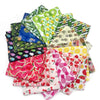 A pile of colorful summer fruit print dog bandanas and triangle scarves made of soft cotton.