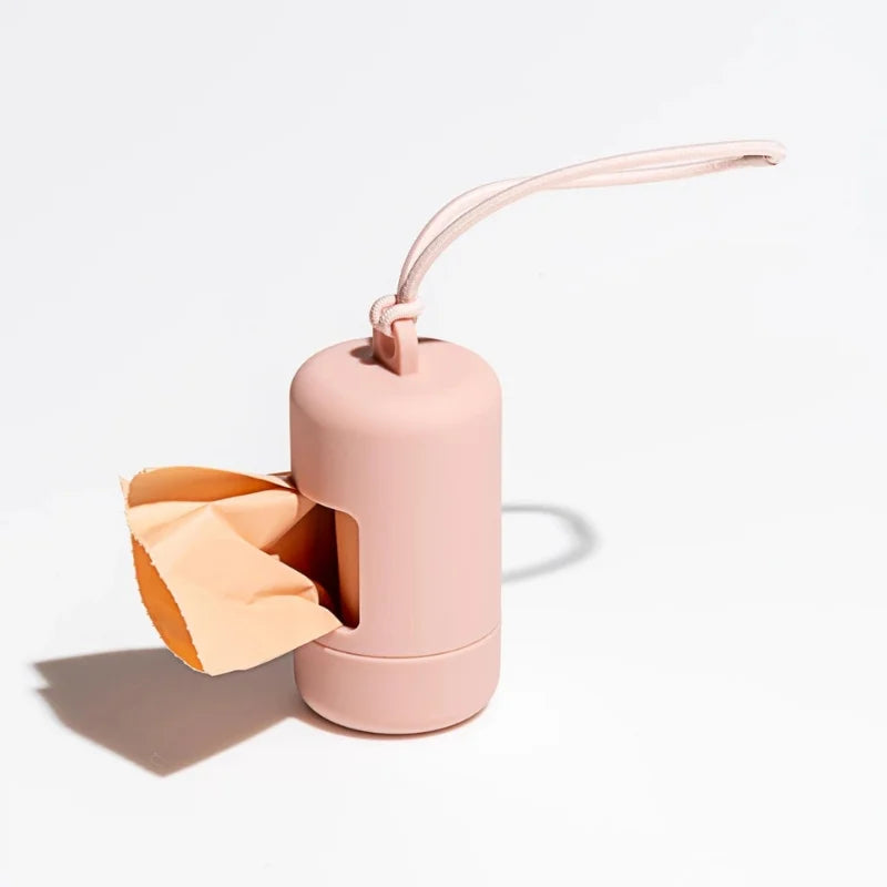 A pink portable dog poop bag dispenser with a flexible strap, shown against a white background.