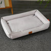 A white waterproof orthopedic dog bed with a removable cover lying on a gray carpet.