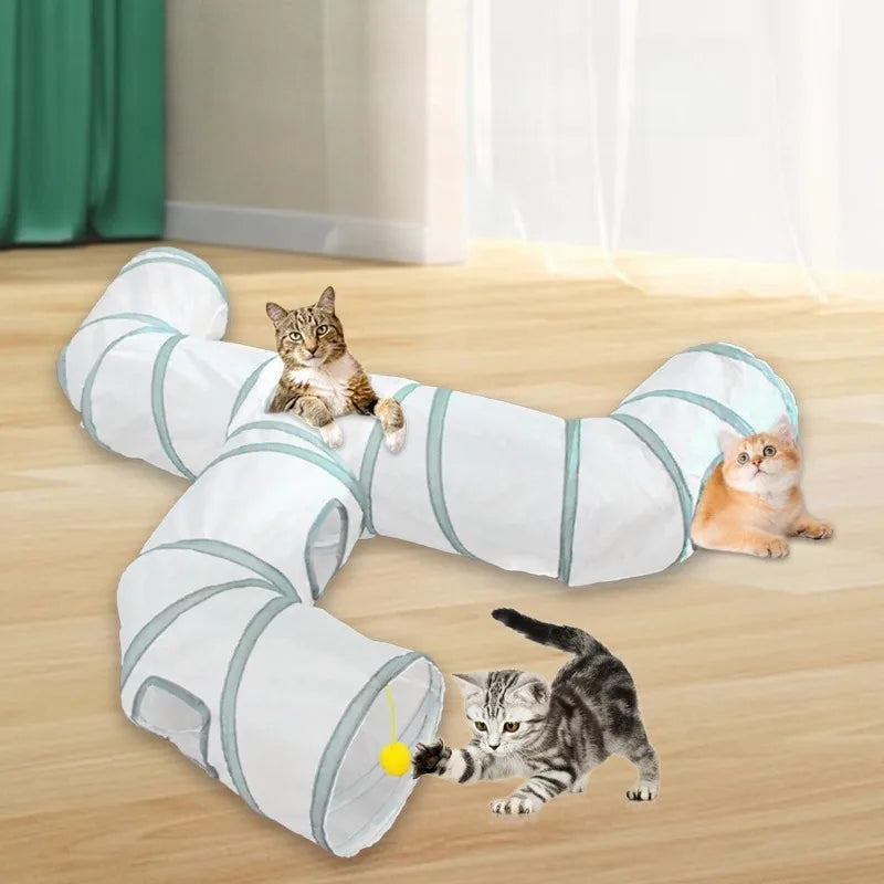 Weißes und türkises zusammenklappbares Katzenspieltunnel auf einem Holzboden mit zwei Katzen, die damit interagieren.